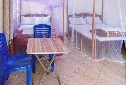 姆巴拉拉Silver Motel Mbarara的一张桌子和椅子,位于带两张床的房间