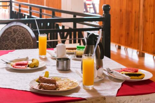 姆巴拉拉Easy View Hotel Mbarara的一张桌子,上面放着两盘食物和橙汁