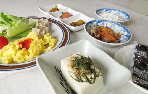 弟子屈町Traveler's Inn Asanebo的餐桌,盘子上放着食物和碗