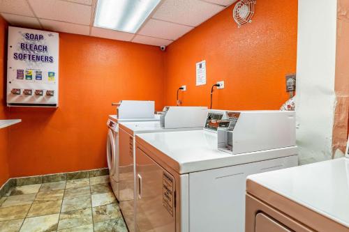 乔利埃特伊利诺伊州乔利埃特六号酒店的洗衣房设有橙色墙壁、洗衣机和烘干机