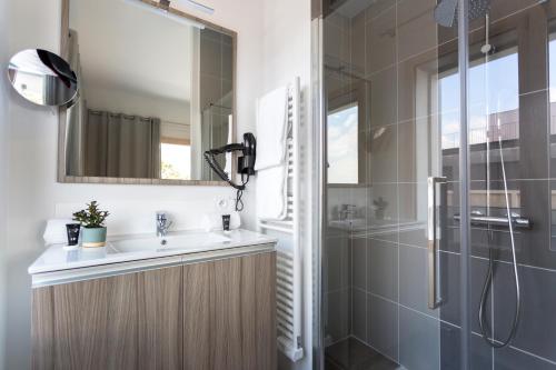 里昂Nemea Appart Hotel So Cloud Lyon Gare Part-Dieu的一间带水槽和淋浴的浴室