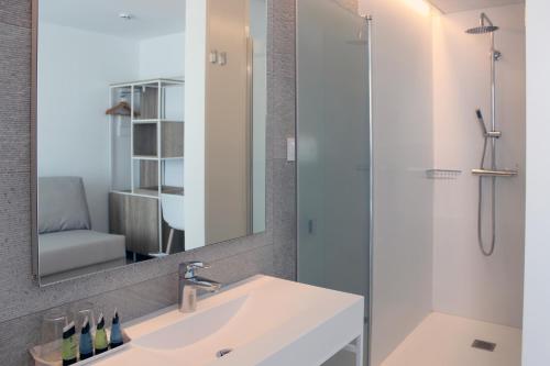 卡内·德·玛尔Rocatel的浴室配有盥洗盆和带镜子的淋浴