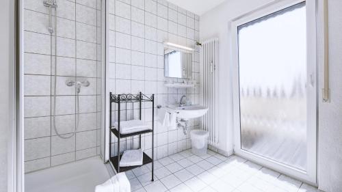 埃尔欣根Hotel Restaurant Austüble的带淋浴和盥洗盆的白色浴室