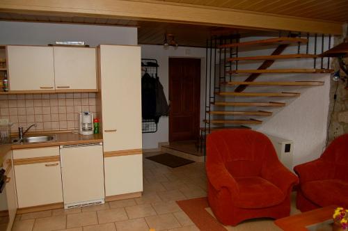 KönigshainFewo Mühlehof的一间带红色椅子和楼梯的厨房