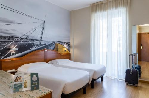 佩斯卡拉佩斯卡拉住宿加早餐酒店的酒店客房设有两张床,墙上挂有绘画作品