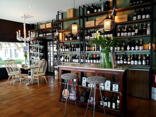 坎巴多斯里韦拉德菲芬安尼斯旅馆的酒吧配有桌子和一些葡萄酒
