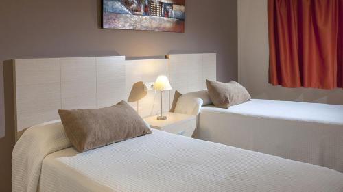 卡尔佩ESTIMAR Calpe Apartments的酒店客房,设有两张床和一盏灯
