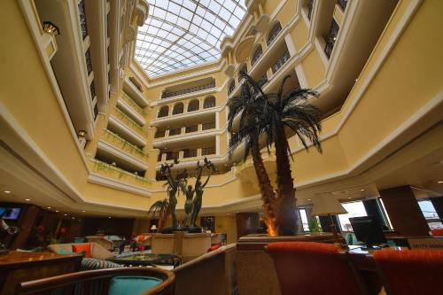 维沙卡帕特南Welcomhotel by ITC Hotels, Devee Grand Bay, Visakhapatnam的大堂,棕榈树和大楼
