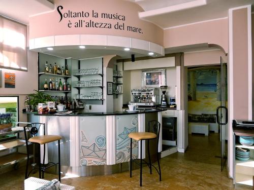 莱圭利亚Hotel Delfino的一间厨房,内设一个柜台和凳子
