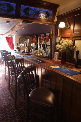 贝奇沃思Red Lion Hotel, Pub & Restaurant的酒吧里摆放着一排椅子的酒吧