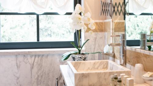 卡拉拉贝尔维多别墅精品酒店的浴室设有水槽和花瓶