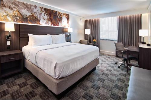 巴吞鲁日Crowne Plaza Executive Center Baton Rouge, an IHG Hotel的酒店客房设有一张大床和一张书桌。