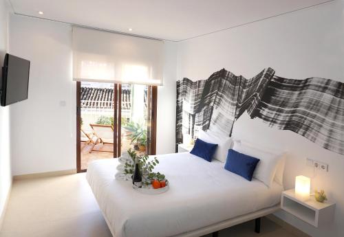 OrbaMardenit Hotel Boutique的卧室配有带蓝色枕头的大型白色床
