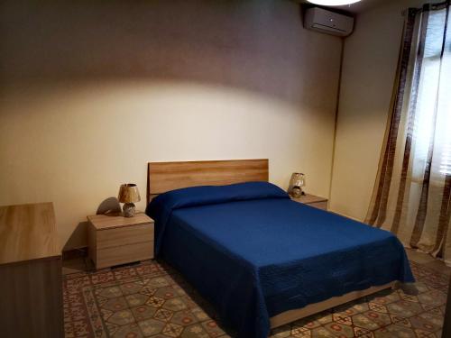 巴勒莫I babbaluci的一间卧室配有一张带蓝色床罩的床