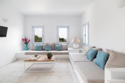 圣玛丽亚The Sand Collection Villas的白色的客厅配有白色的沙发和蓝色的枕头。