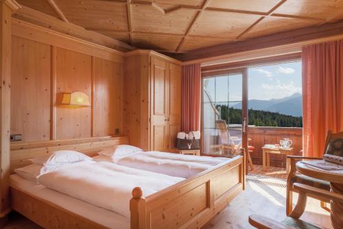 蒂罗尔-泽费尔德拉城霍夫纳期酒店的一间卧室设有两张床和大窗户