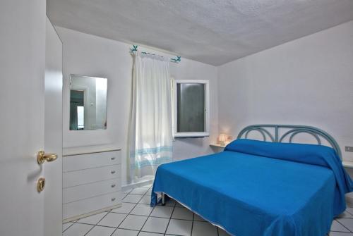 罗通多港Residence Stella Di Gallura的一间卧室设有蓝色的床和窗户。