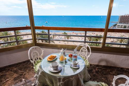 阿利坎特ATICO POSTIGUET的一张带食物的桌子,享有海滩美景