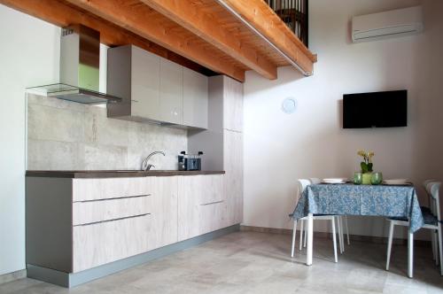 DrugoloCorte la Selva的一间带桌子和水槽的厨房以及一台电视