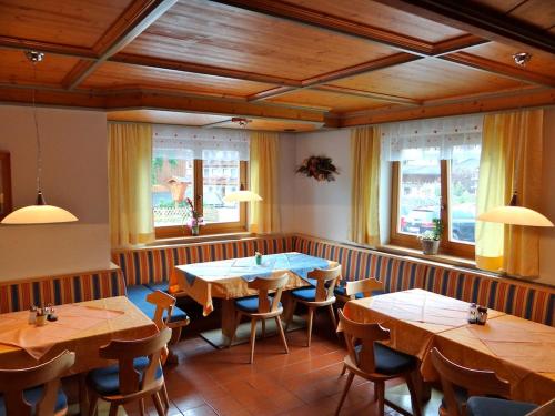 萨尔巴赫玛丽亚滑雪和自行车膳食公寓的餐厅设有木桌、椅子和窗户。