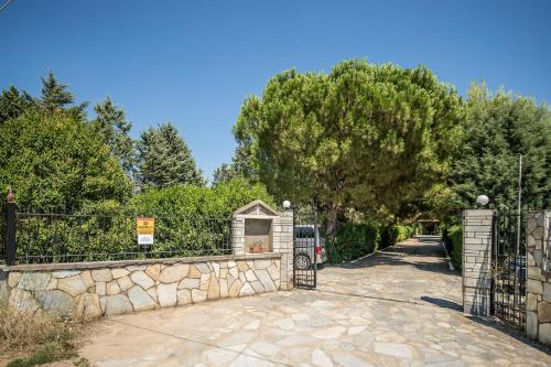 塞萨洛尼基Villa Ampelos的通往带石墙的车道的大门
