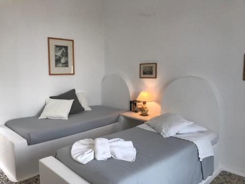 纳乌萨斯沃罗欧斯洋房酒店的一间卧室配有两张带毛巾的床