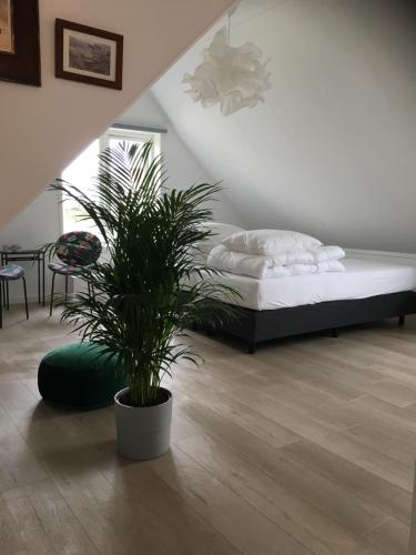 滨海卡特韦克Kamers van Goud的一间卧室配有一张床和盆栽植物