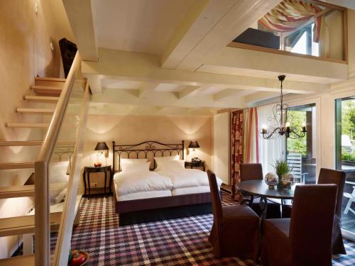 波彭豪森兰道思霍夫瓦瑟库佩酒店的一间卧室配有一张床、一张桌子和楼梯