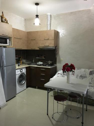 Kvariat'iАпартаменты свидом наморе Гонио的厨房配有桌子、炉灶和洗碗机。