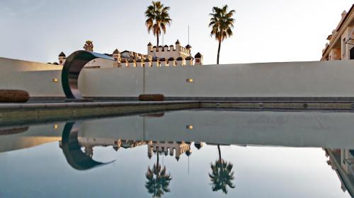 翁蒂年特卡萨尔酒店的一座棕榈树游泳池和一座建筑