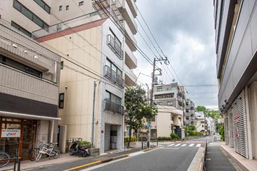 东京Uhome Tabata Apartment的城市中一条空荡荡的街道,有建筑