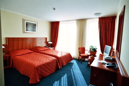 斯拉沃尼亚布罗德萨维斯酒店的酒店客房配有一张床和一张带电脑的书桌