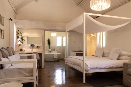 楚梅布Conductor's Inn的一间卧室设有天蓬床和一间浴室。