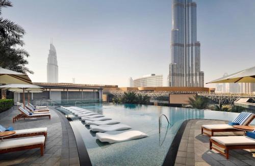 迪拜2 Bedroom with Full Burj view的一个带躺椅的游泳池,享有城市天际线
