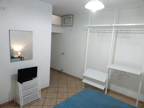 莱乌卡Casa vacanza Leuca的一个小房间,配有电视和镜子