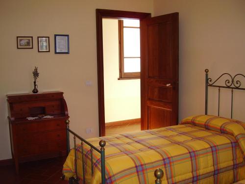 Pianopoli卡洛里农家乐 的一间卧室配有一张床、一个梳妆台和一扇窗户。