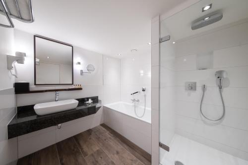 阿姆斯特丹彼尔德伯格酒店的白色的浴室设有水槽和淋浴。