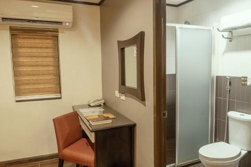 马尼拉卡萨博可博酒店的一间带卫生间的浴室和一张带电话的书桌