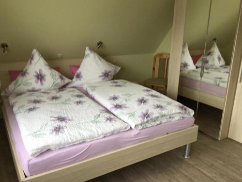 塔廷格Haus Fabricius的一张带紫色和白色床单及枕头的床