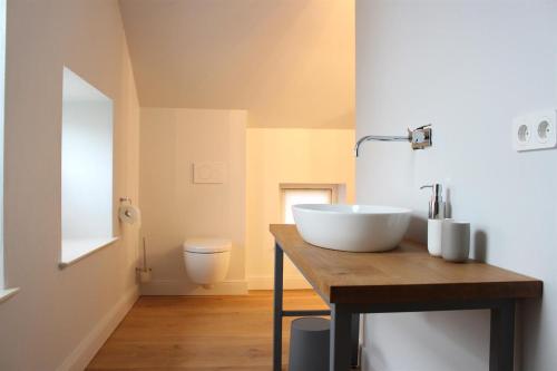 圣彼得奥尔丁Ferienhäuser SPO的木制柜台上带白色水槽的浴室
