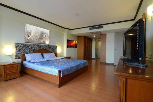 曼谷Omni Towers - Large 1 Bedroom Condo Soi Nana的一间卧室配有一张床和一台平面电视
