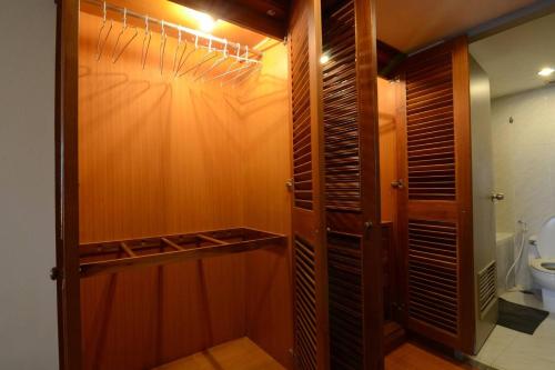 曼谷Omni Towers - Large 1 Bedroom Condo Soi Nana的一间带卫生间的浴室和一个木制衣柜
