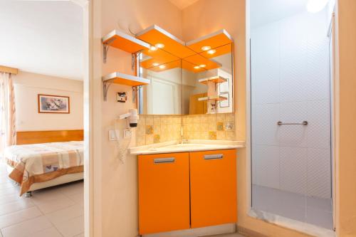 库萨达斯金门酒店的橙色的浴室设有水槽和淋浴。