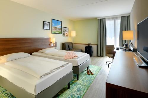 辛德尔芬根斯图加特辛德芬根梅斯美居酒店的酒店客房配有两张床和一张书桌