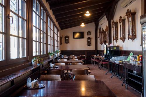 乌赫尔堡赫吉玛纳萨洛维奇酒店的餐厅设有木桌、椅子和窗户。
