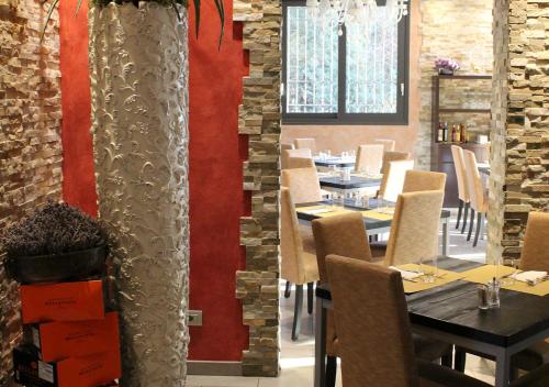 VerdelloQuattro Gatti Rooms&Suite的一间带桌椅和红色墙壁的餐厅