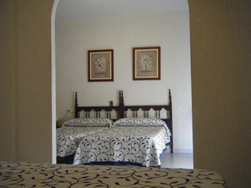 阿尔哈拉克穆里尔旅馆的卧室配有一张带白色和黑色棉被的床