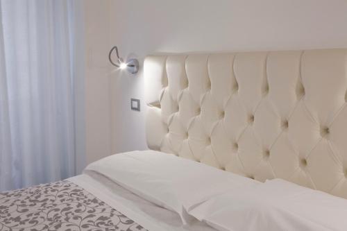 维罗纳穆赛奥公寓的卧室内的一张带白色床头板的床