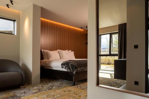 NesjavellirION Adventure Hotel, Nesjavellir, a Member of Design Hotels的一间卧室配有一张带镜子的床和窗户