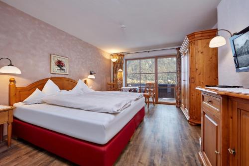 米滕瓦尔德米滕瓦尔德索恩比赫兰德豪斯酒店的一间卧室设有一张大床和一个大窗户